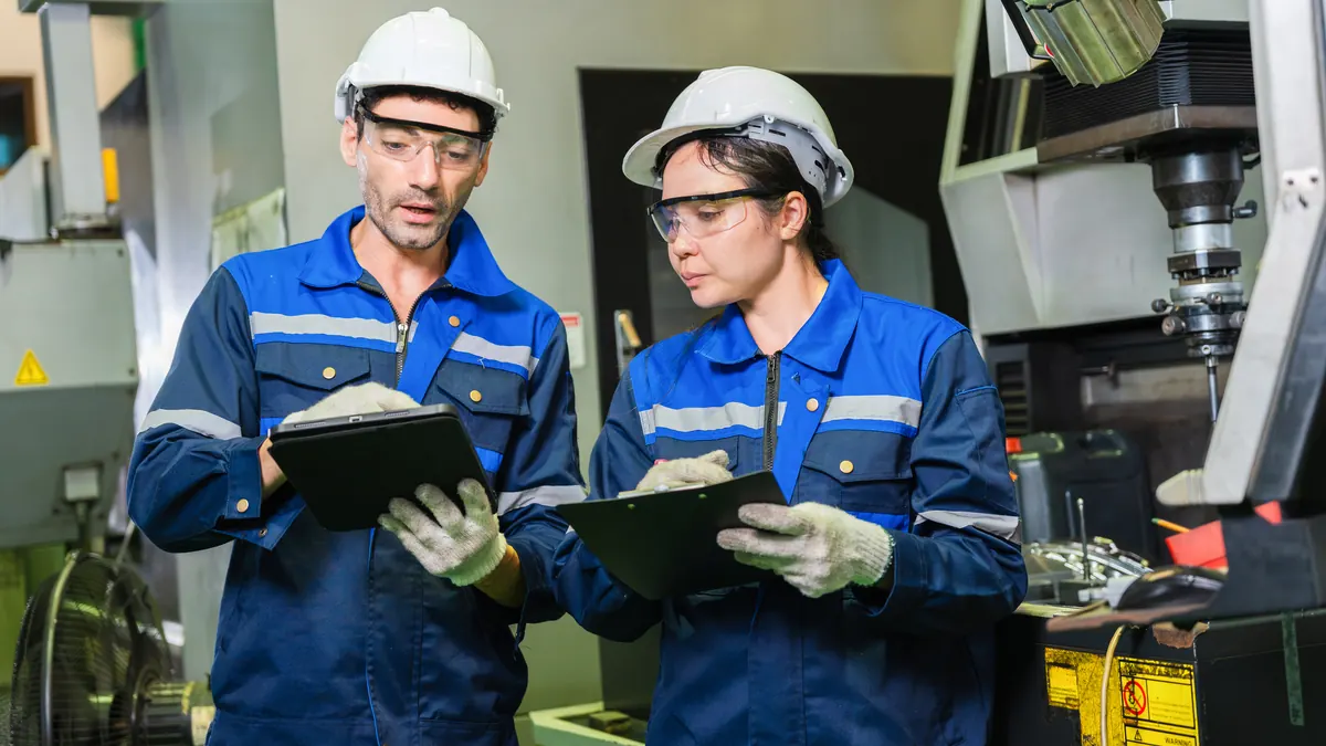 Two engineers review measurement data at a plant.