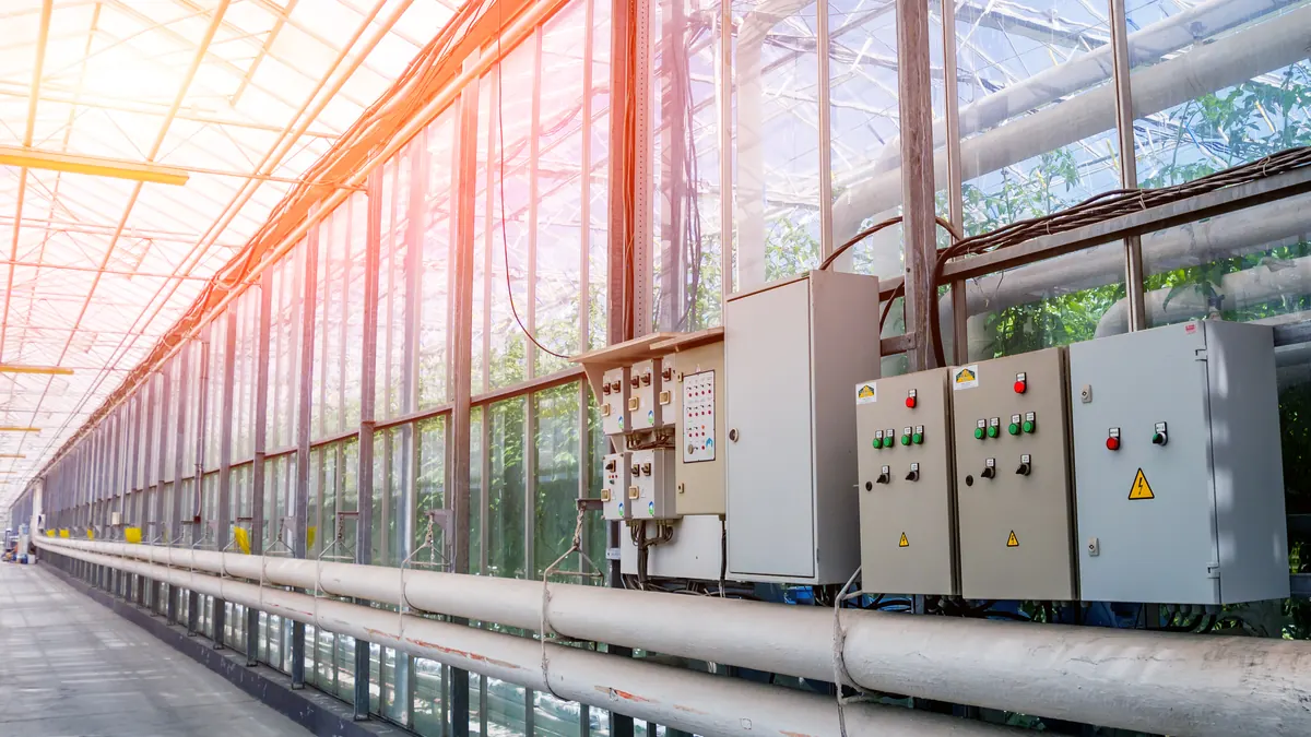 Electrical panels and heating pipes inside a greenhouse.