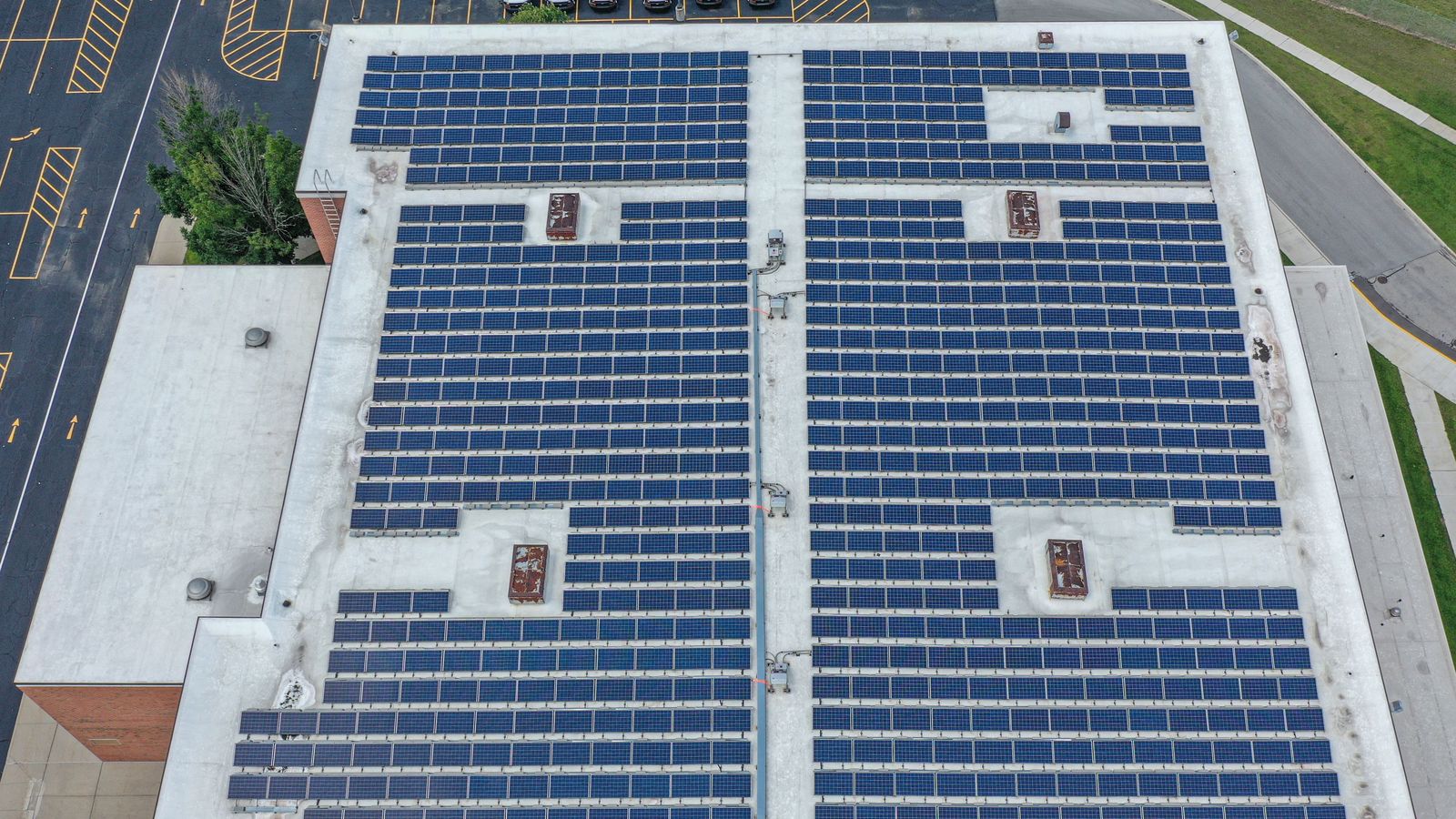 Aerial view of a commercial roof covered with solar panels.