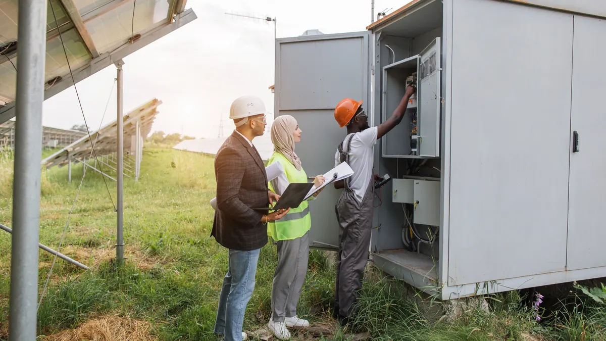 Engineers inspect an electrical cabinet in the field.
