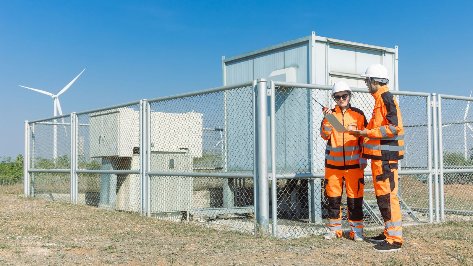 Engineers at a fenced storage site.