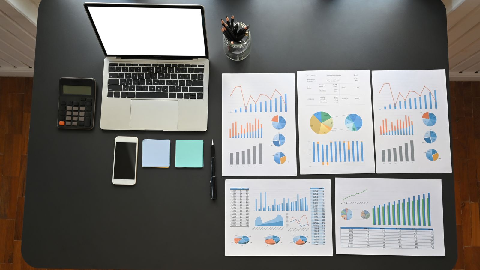 Desk with a computer and financial charts.