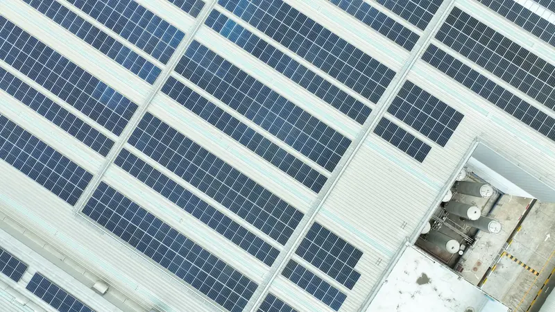 Paneles solares sobre el techo de una nave industrial.